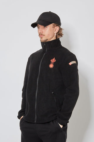 CH+ARMED Artillerie Fleece in Schwarz mit roter Bomben Stickerei, Badge Klett und verstellbarem Bund – angewinkelte Ansicht.