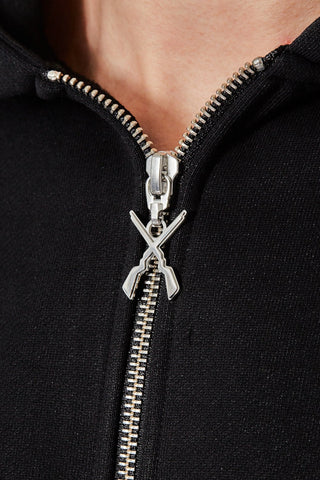 Nahaufnahme des personalisierten Reissverschlussanhängers mit gekreuzten Gewehren am CH+ARMED Infanterie Zip Hoodie.