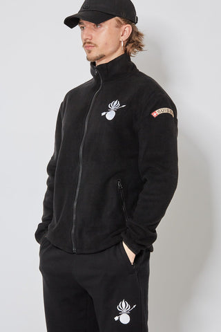 CH+ARMED Isone Gren Fleece in Schwarz mit weisser Stickerei, Badge Klett und verstellbarem Bund – angewinkelte Ansicht.