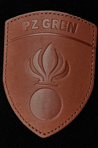 CH+ARMED Leder Badge mit gepresstem Grenadier Emblem, 100% braunes Echtleder mit geprägtem Militärsymbol, stilvolles Detail für Streetwear oder Collectibles.