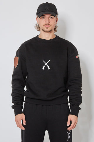 Schwarzes CH+ARMED Sweatshirt für Herren mit weissem Infanterie Logo auf der Brust, lockerer Schnitt, kombiniert mit schwarzer Cap und Jogginghose – Frontansicht